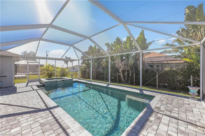View of pool with a sunroom, glass enclosure, a pool with connected hot tub, and a patio area