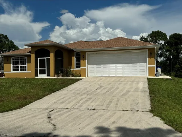 View of front of home featuring a garage and a front yard