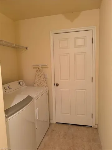 Laundry room with light tile patterned flooring and washer and dryer