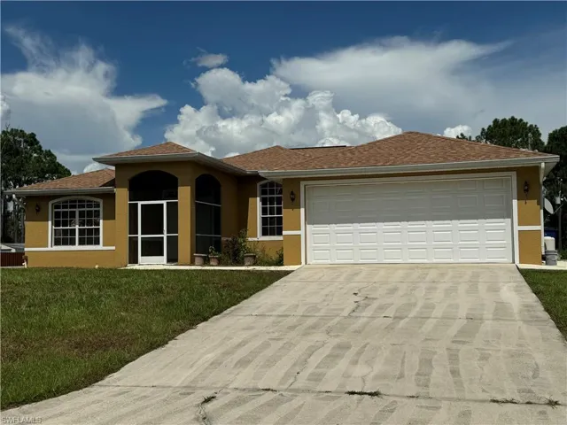 View of front of home with a garage and a front yard