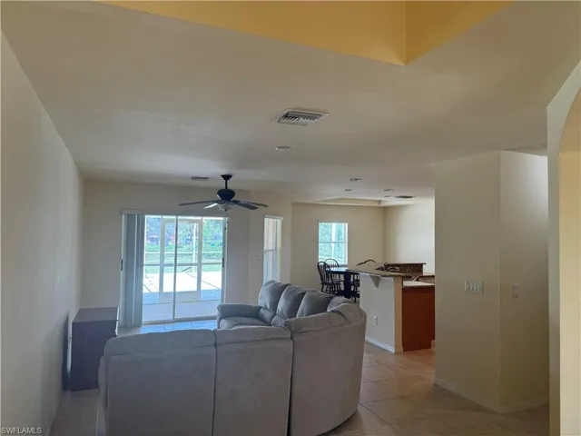 Tiled living room featuring ceiling fan