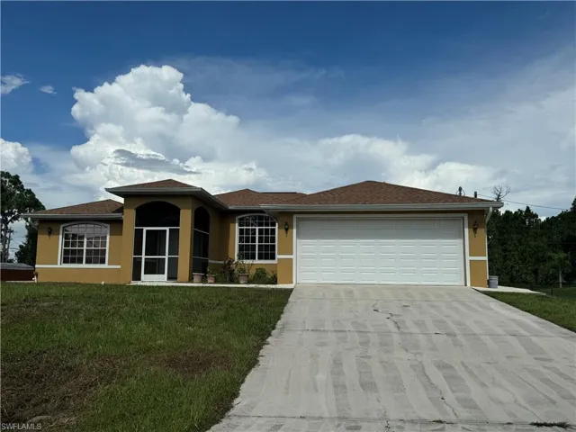 View of front of house with a garage and a front yard