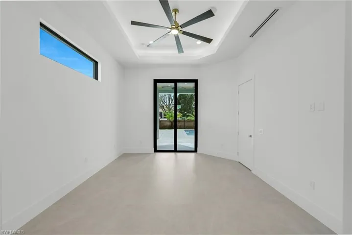 Spare room featuring a ceiling fan and a tray ceiling
