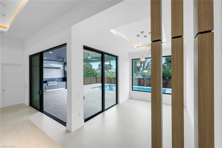 Doorway featuring a raised ceiling and a chandelier