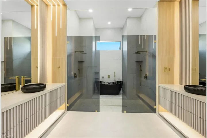 Full bath featuring vanity, a marble finish shower, recessed lighting, and a soaking tub
