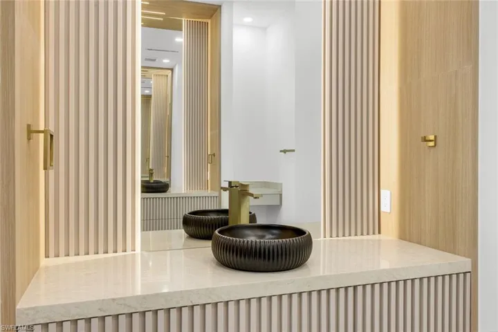 Bathroom view of radiator heating unit, wallpapered walls, and recessed lighting