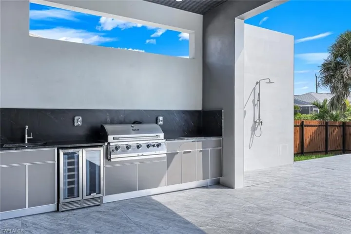 View of patio featuring wine cooler and an outdoor kitchen