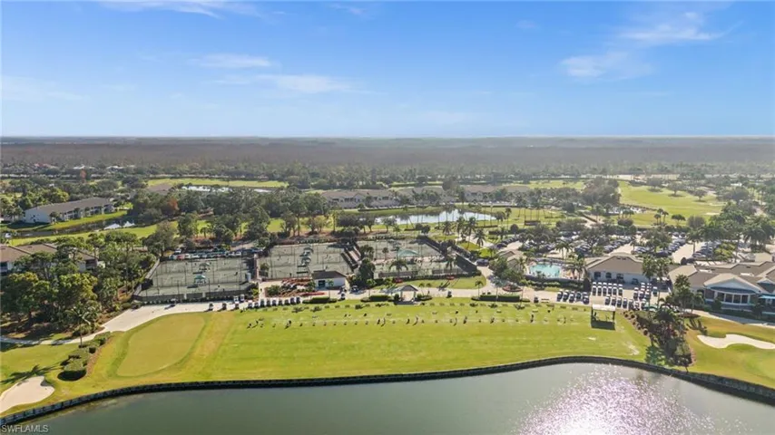Aerial view of property's location with a nearby body of water, a local golf course, and nearby suburban area