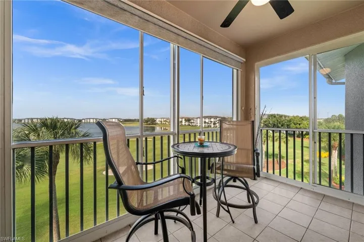 Sunroom / solarium with tile patterned floors and a water view