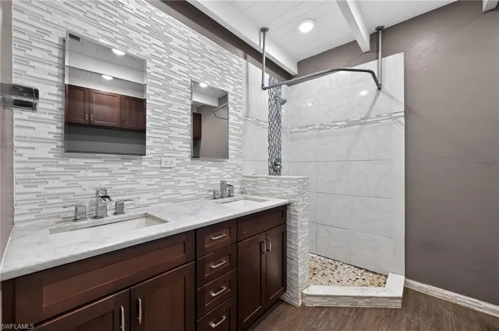 Dual vanity with white countertop, chrome fixtures, and dark wood cabinetry