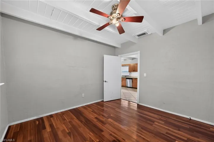 Rich wood-finish flooring complements the neutral wall color and white baseboards