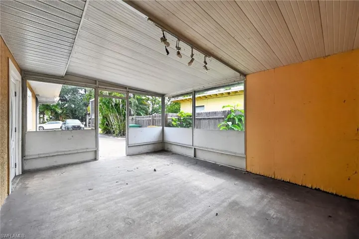 Covered outdoor patio with a concrete floor and a light-colored slatted ceiling