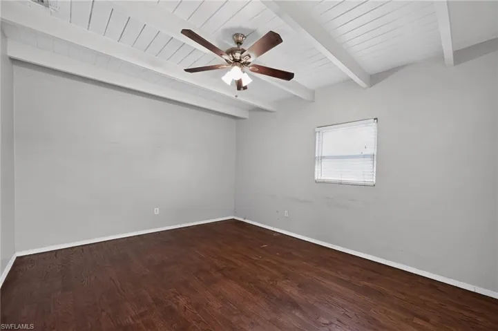 Vaulted ceiling with exposed white beams and a ceiling fan
