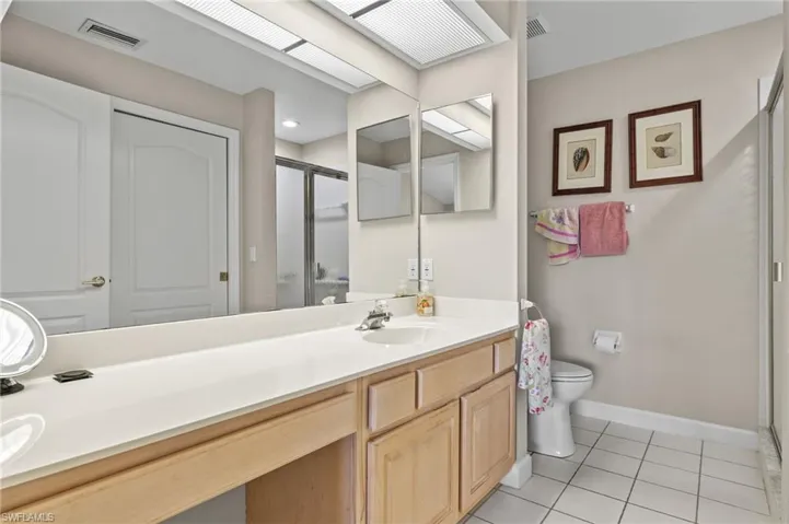 Bathroom with tile patterned floors, vanity, shower and toilet