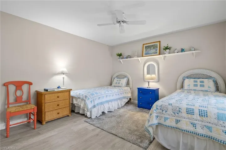 Bedroom featuring ceiling fan and light ; large closet vinyl wood-style floors