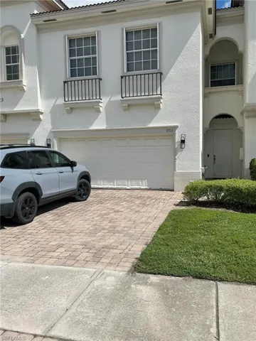 Mediterranean / spanish house featuring decorative driveway, a garage, stucco siding, and a tile roof
