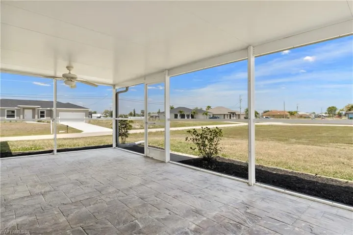 Unfurnished sunroom with a residential view and a ceiling fan