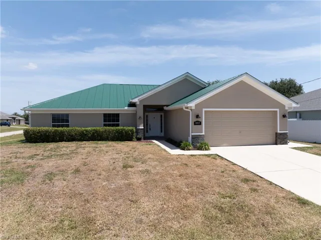 Single story home with concrete driveway, an attached garage, fence, a front yard, and stucco siding