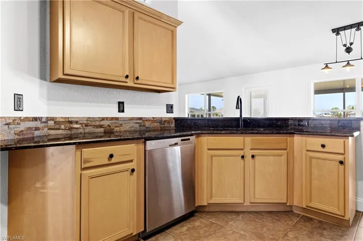 Kitchen featuring dishwasher, a healthy amount of sunlight, light brown cabinetry, and a sink