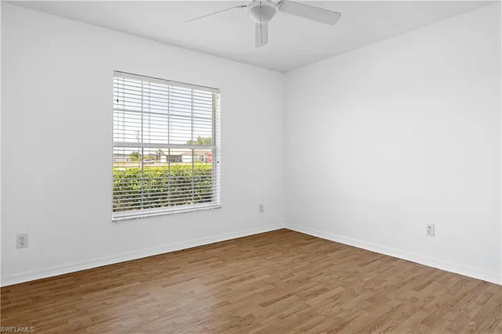 Empty room featuring baseboards, a ceiling fan, and light wood-type flooring