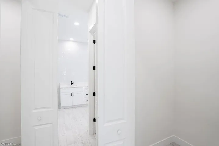 Corridor featuring sink and light wood-type flooring