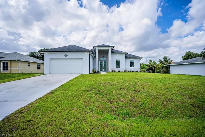 View of front of house with a garage and a front yard
