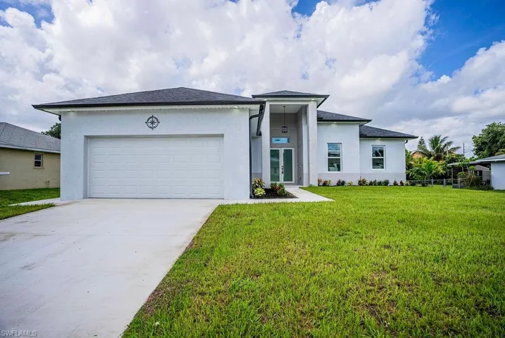 View of front facade featuring a garage and a front yard