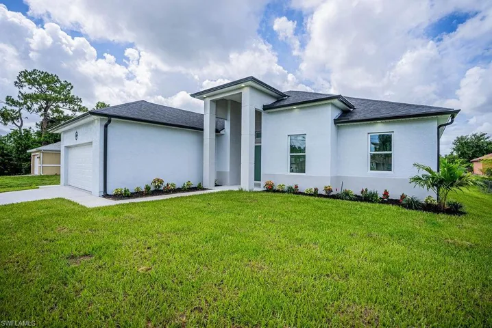 View of front facade with a garage and a front lawn