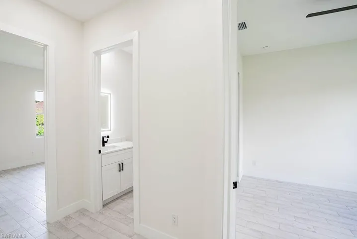 Hallway with sink and light wood-type flooring