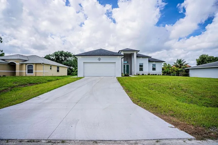 View of front of home featuring a garage and a front yard