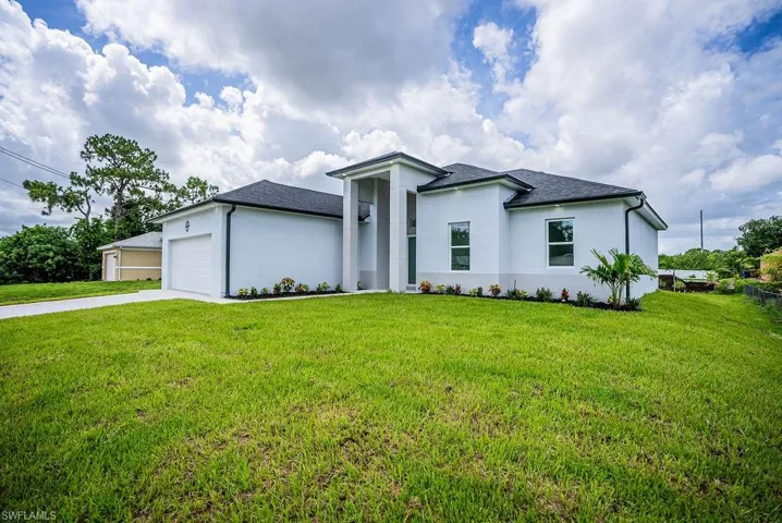 View of front of property featuring a garage and a front yard