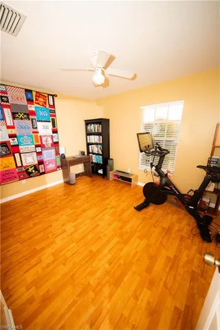 Workout room featuring light hardwood / wood-style floors and ceiling fan