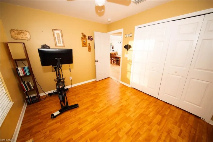 Exercise room featuring ceiling fan and hardwood / wood-style flooring