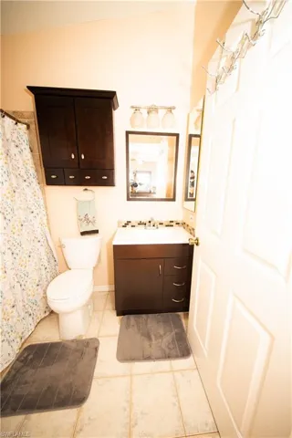 Bathroom featuring tile patterned flooring, vanity, and toilet