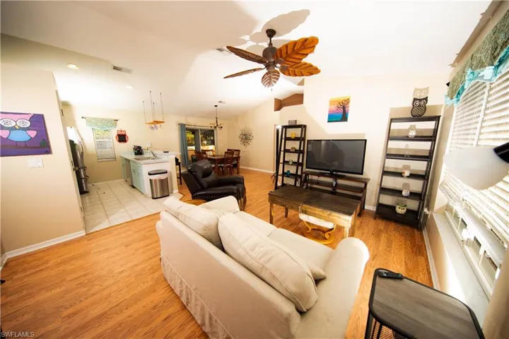 Living room featuring vaulted ceiling, light hardwood / wood-style flooring, plenty of natural light, and ceiling fan