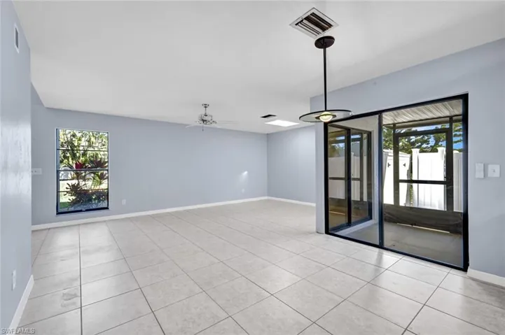 Unfurnished room featuring a ceiling fan, plenty of natural light, and light tile patterned floors
