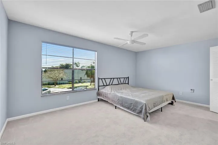 Bedroom with light carpet and ceiling fan