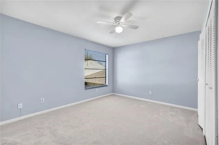 Unfurnished bedroom with a closet, light colored carpet, and ceiling fan