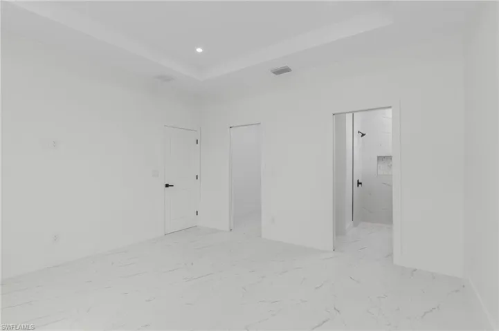 Room featuring white walls and white marble-look flooring