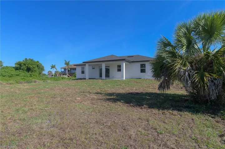 Expansive rear yard with natural landscaping