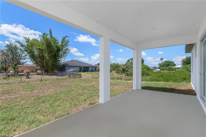 Covered patio with a concrete slab, white columns, and a smooth ceiling