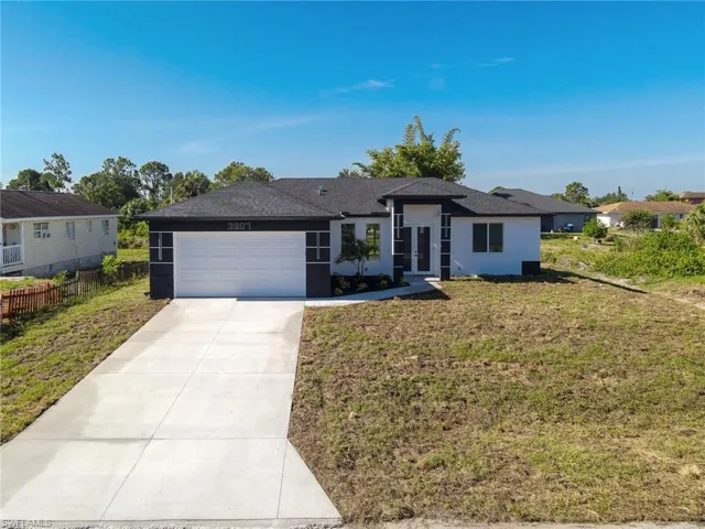 Contemporary single-story residence with a black shingle roof and white stucco exterior accented with black architectural details