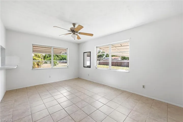 Empty room with a ceiling fan and light tile patterned floors