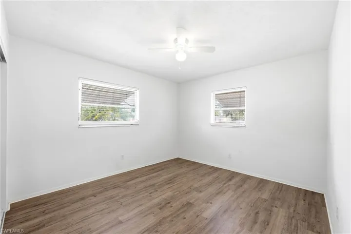 Empty room featuring wood finished floors and a ceiling fan