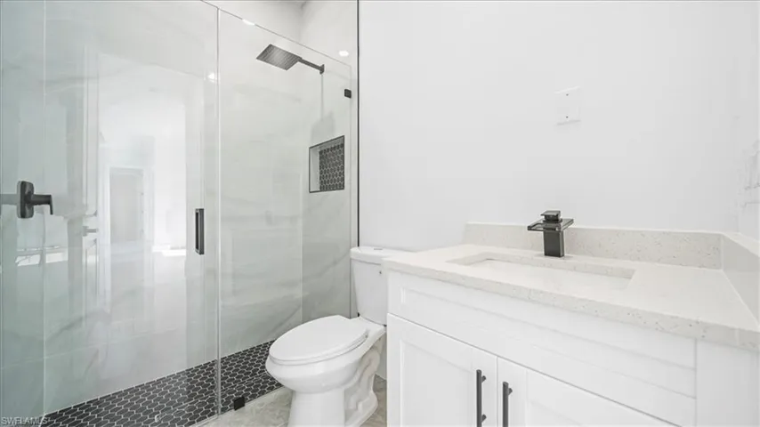 Full bathroom featuring vanity and a shower stall