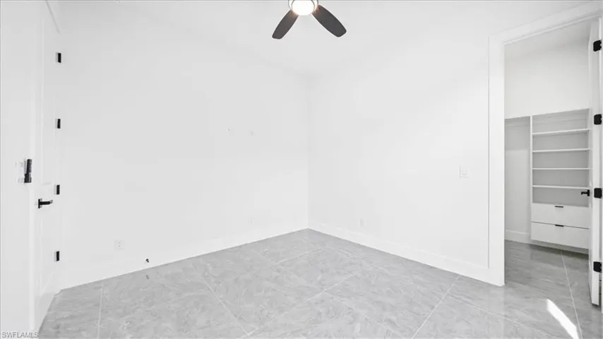 Unfurnished bedroom with a spacious closet and ceiling fan
