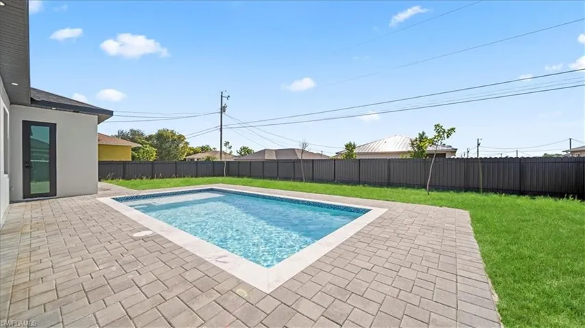View of swimming pool featuring patio surround and a fenced backyard