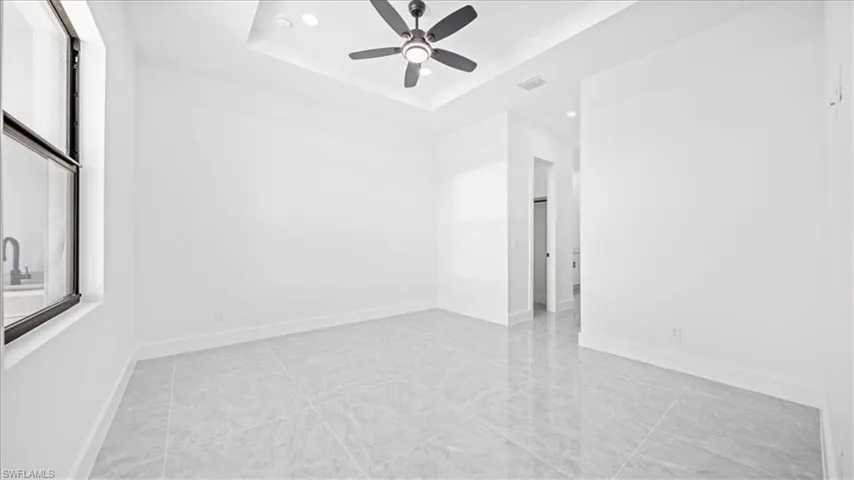 Spare room featuring a ceiling fan, a tray ceiling, and recessed lighting