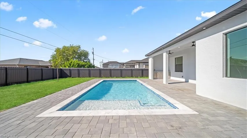 View of swimming pool with patio surround and a fenced backyard