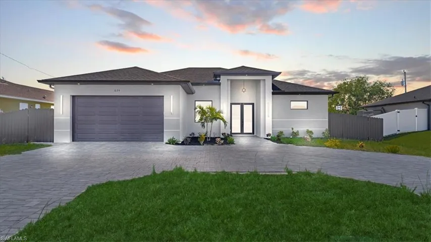 View of front of house with stucco siding, a gate, decorative driveway, and an attached garage